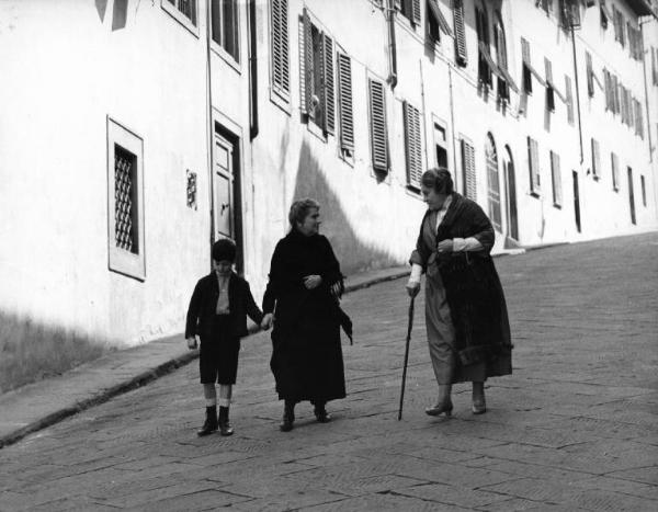 Set del film "Cronaca familiare" - Regia Valerio Zurlini 1962 - Un bambino e due donne anziane camminano per una strada in discesa.