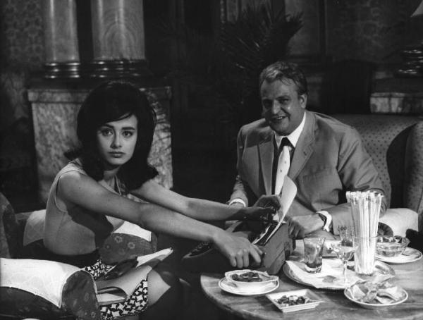 Fotografia del film "La cuccagna" - Regia Luciano Salce 1962 - L'attrice Donatella Turri e l'attore Umberto D'Orsi seduti ad un tavolino su cui c'è una macchina da scrivere.
.
