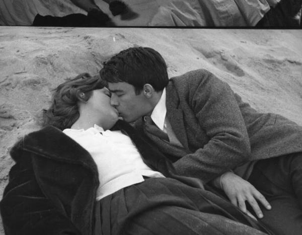 Fotografia del film "I delfini" - Regia Francesco Maselli 1960 - L'attrice Anna Maria Ferrero e l'attore Gérard Blain si baciano stesi sulla sabbia.