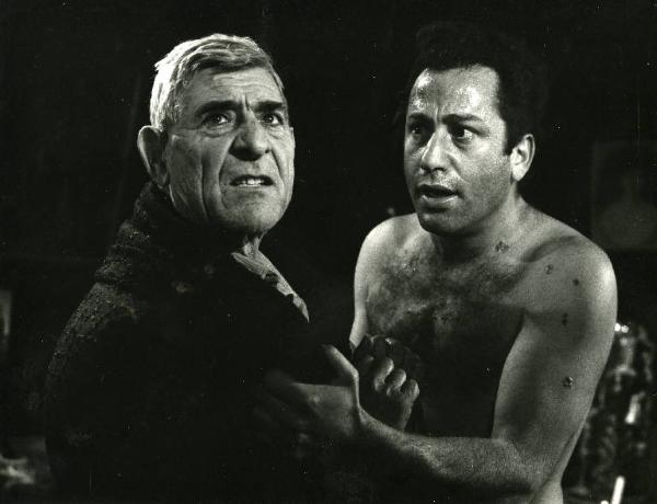 Scena del film "Il demonio" - Regia Brunello Rondi, 1963 - Frank Wolff a torso nudo con segni di bruciature, tiene per il bavero un uomo che digrigna i denti.