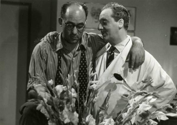 Sul set del film "Diagnosi" - Regia Ferruccio Cerio, 1942 - Il regista e Sandro Ruffini, in camice da medico, abbracciati sul set.