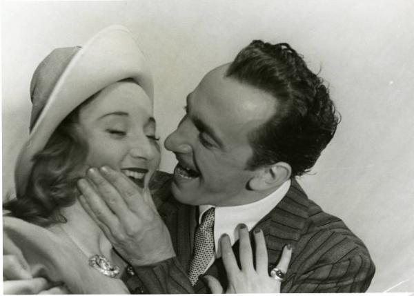 Sul set del film "Divieto di sosta" - Regia Marcello Albani, 1941 - Primo piano di Nino Crisman mentre afferra il mento di Silvia Manto.