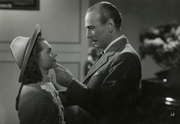 Scena del film "Divieto di sosta" - Regia Marcello Albani, 1941 - Mezza di figura di Mario Ferrari che, con una mano solleva il viso di Paola Veneroni. I due si guardano.