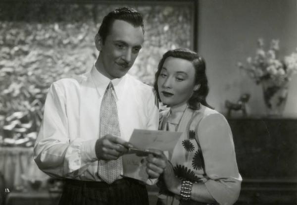 Scena del film "Divieto di sosta" - Regia Marcello Albani, 1941 - Mezza figura di Nino Crisman mentre mostra una lettera a Silvia Manto.