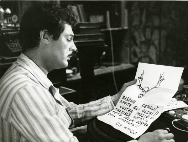 Scena del film "Divorzio all'italiana" - Regia Pietro Germi, 1961 - Mezza figura di profilo di Marcello Mastroianni, mentre legge una lettera anonima che lo avvisa del tradimento.