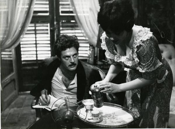 Scena del film "Divorzio all'italiana" - Regia Pietro Germi, 1961 - Daniela Rocca serve il caffè a Marcello Mastroianni che, seduto, la guarda torvo.
