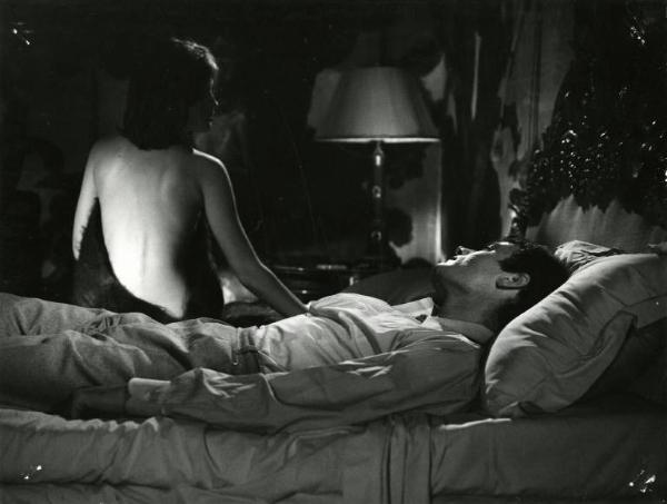 Scena del film "I dolci inganni" - Regia Alberto Lattuada, 1960 - Jean Sorel, vestito, sdraiato supino su un letto, guarda Catherine Spaak, seduta sul bordo, di spalle, con la schiena nuda.