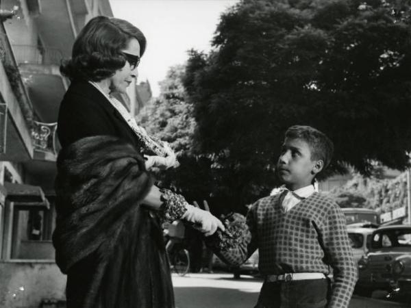 Scena del film "I dolci inganni" - Regia Alberto Lattuada, 1960 - Piano americano di un'attrice non identificata che tende la mano a un bambino.