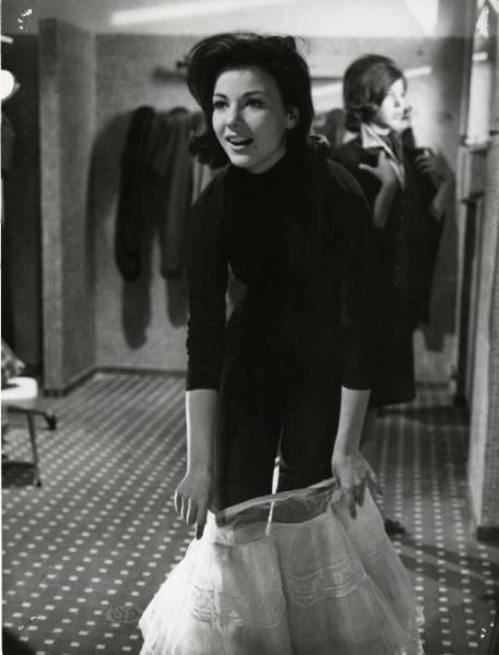 Scena del film "I dolci inganni" - Regia Alberto Lattuada, 1960 - Marilù Tolo in piedi mentre si infila un gonnellino di tulle.