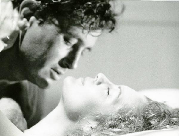 Scena del film "Una donna alla finestra" - Regia Pierre Granier-Deferre, 1977 - Primo piano di profilo di Romy Schneider sdraiata con gli occhi chiusi e il mento alzato. Victor Lanoux, sopra di lei, con il viso vicinissimo.