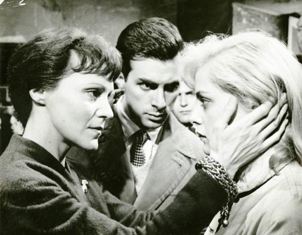 Scena del film "La donna del giorno" - Regia Francesco Maselli, 1957 - Primo piano di profilo di Elisa Cegani, a sinistra, tiene tra le mani il volto di Virna Lisi. Dietro di loro, Antonio Cifariello, guarda Virni Lisi.