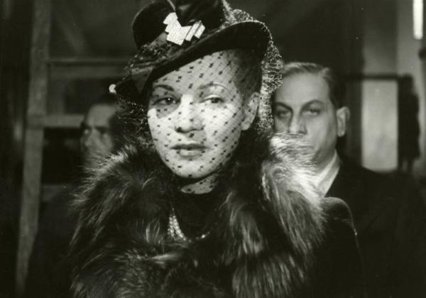 Scena del film "Diagnosi" - Regia Ferruccio Cerio, 1942 - Primo piano di Luisa Ferida con un cappello con il velo di pizzo tirato sul volto. Alle sue spalle un attore non identificato.