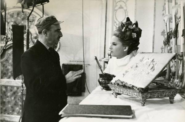 Sul set del film "Don Giovanni in Sicilia" - Regia Alberto Lattuada, 1967 - In una chiesa, mezza figura di profilo di Alberto Lattuada, mentre istruisce Katia Moguy in piedi di fronte a lui, nella veste di una da sposa.