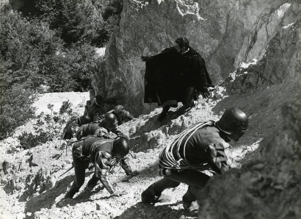 Scena del film "Il duca nero" - Regia Pino Mercanti, 1963 - Cameron Mitchell durante una salita in montagna. L'attore esorta altri interpreti non identificati a scalare la parete rocciosa.