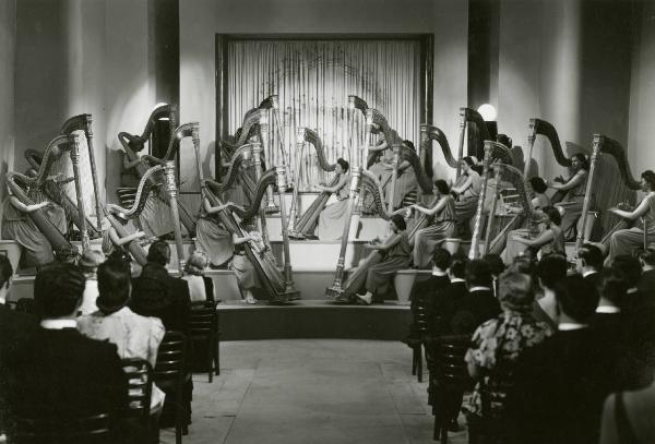 Scena del film "Due occhi per non vedere" - Regia Gennaro Righelli, 1939 - Totale di un'orchestra di sole arpe che si esibisce davanti a una platea di spalle.