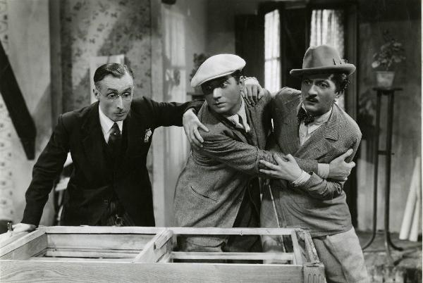 Scena del film "Duetto vagabondo" - Regia Guglielmo Giannini, 1938 - Nino Besozzi, al centro, e Enrico Viarisio, a destra, si trattengono a vicenda. Intanto dietro, un attore non identificato poggia la mano destra su Nino Besozzi.
