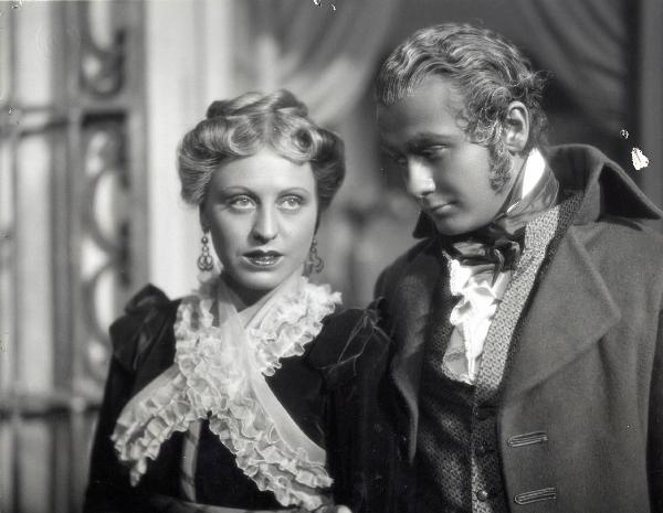 Scena del film "Elisir d'amore" - Regia Amleto Palermi, 1941- A destra, Roberto Villa osserva con attenzione Margherita Carosio, a sinistra, che guarda dritto davanti a sé.