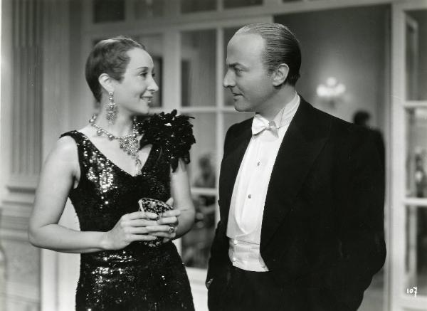 Scena del film "Enrico IV" - Regia Giorgio Pastina, 1943 - A destra, Osvaldo Valenti e a sinistra, Clara Calamai sorridenti, in abiti eleganti, si scambiano uno sguardo di intesa.