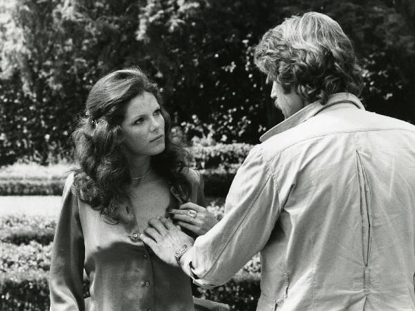 Scena del film "L'etrusco uccide ancora" - Regia Armando Crispino, 1972 - Samantha Eggar si scosta la camicia con la mano sinistra, mentre Alex Cord, di spalle, le appoggia la mano sinistra sul petto.