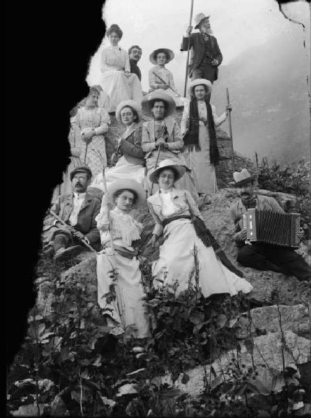 Alta Val Brembana. Ritratto di un gruppo di gitanti in montagna accompagnati da un suonatore di fisarmonica