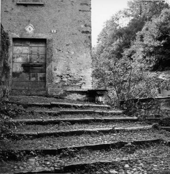 Casa rustica, in primo piano scalinata in pietra e ciottoli
