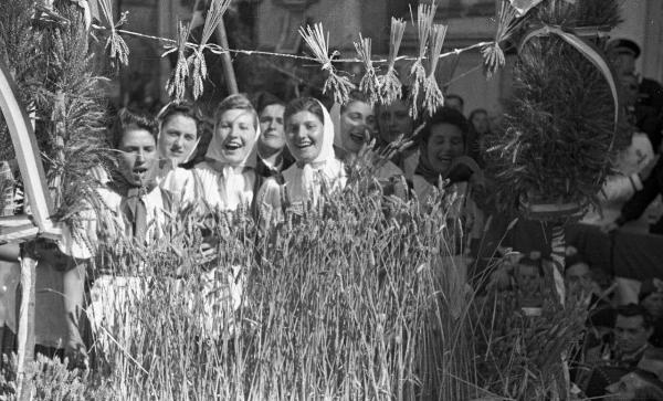 Garlasco - Piazza della Repubblica (già Vittorio Emanuele II) - Festa delle mondine - Gruppo di giovani donne intona un canto - Mazzo di spighe di riso in primo piano - Folla di persone