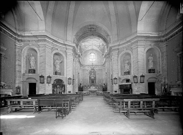 Borgo San Siro - Chiesa di San Siro - Interno - Navata centrale con panche lignee posizionate davanti all'altare maggiore - Sculture marmoree entro nicchie