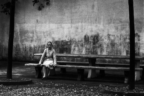 Firenze - Ospedale psichiatrico - Esterno - Malata seduta su una panchina
