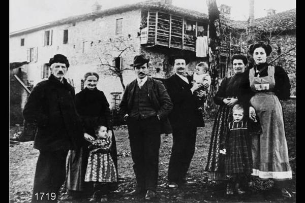 Famiglia Moscheni. Ritratto di famiglia contadina in posa davanti alla propria casa.