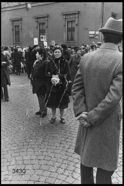 Carnevale ambrosiano, sabato grasso. Piazza Fontana: donna in mezzo alla folla con una maschera in mano.