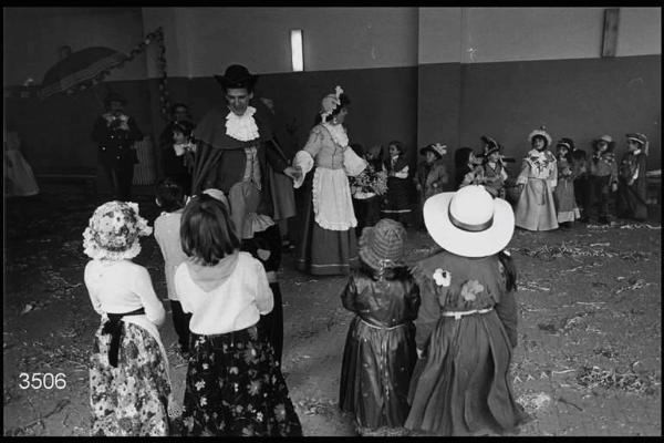 Carnevale ambrosiano. Piccolo Cottolengo di Don Orione: Nino Rossi in costume da Meneghino, Wilma De Angeli in costume da Cecca insieme a un gruppo di bambini in maschera.