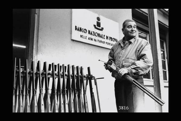 Esterno del Banco Nazionale di prova delle armi da fuoco portatili: un armaiolo ritira i fucili .