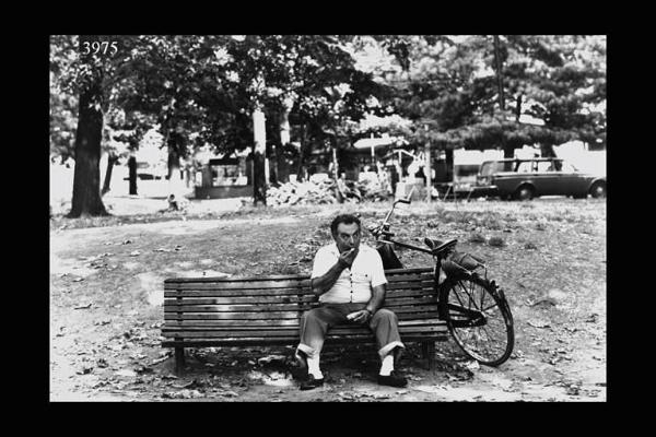 Milano. Parco Sempione. Festa dell'Unità: uomo mangia un gelato su una panchina.