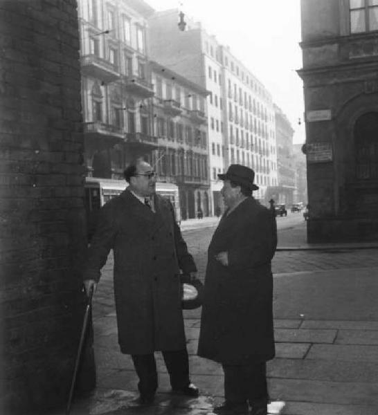 Milano. Due uomini conversano all'angolo di una strada.