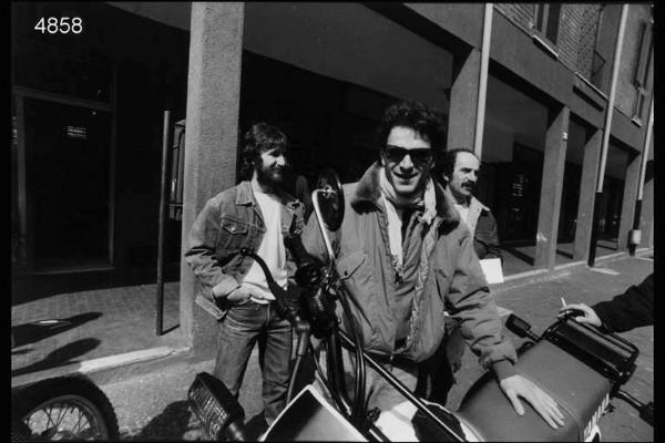 Quarto Oggiaro. Giovane dietro ad una moto Yamaha. Sullo sfondo due uomini guardano fuoricampo.