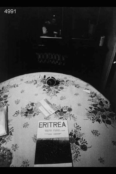 In primo piano fascicolo intitolato "Eritrea" sopra tavolo da pranzo.