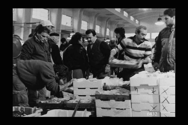 Milano. Via Sammartini 71. Mercato Ittico. Venditori prelevano le cassette di pesce richieste dai clienti.