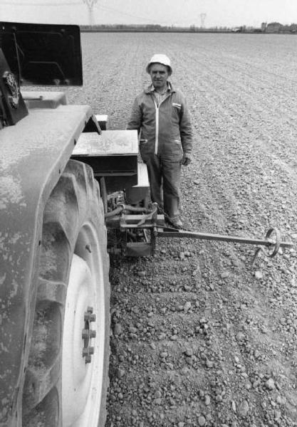 Azienda agricola: Cascina S. Antonio. Coltivazione: granoturco. Semina. Coltivatore nel campo a lato della macchina agricola.