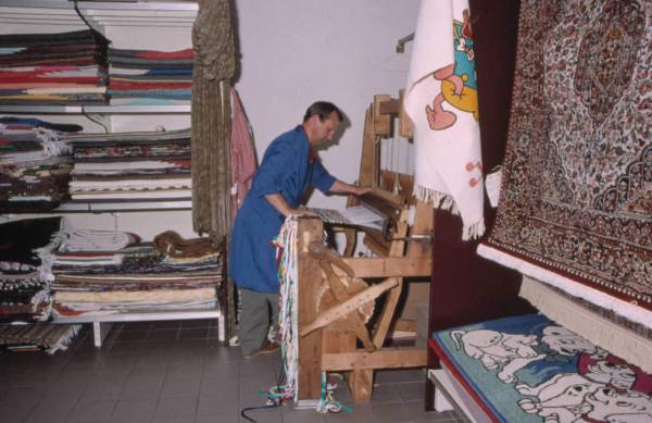 Tappeti esposti o piegati su ripiani nel negozio. I pezzotti di Arigna. (Luoghi della tradizione del lavoro).