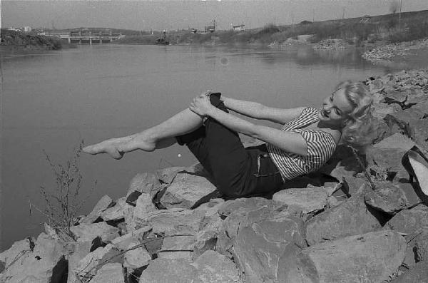Località non identificata. L'attrice Maria Teresa Vianello ritratta seduta sulla riva di un fiume