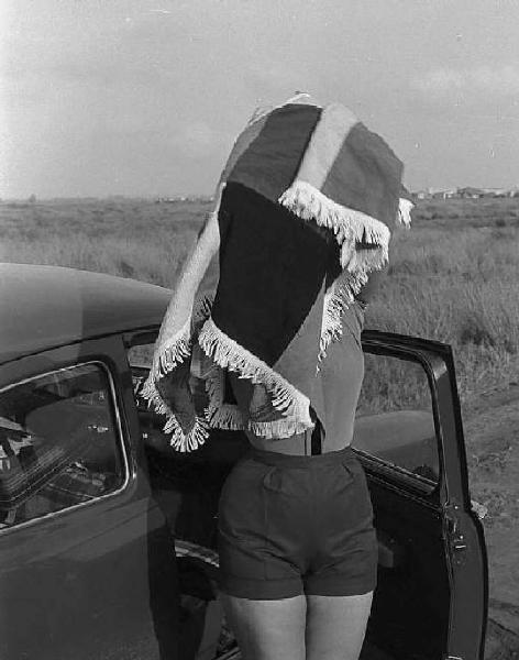 Roma. Periferia. Sofia Loren, vicino ad un' automobile, indossa un poncho