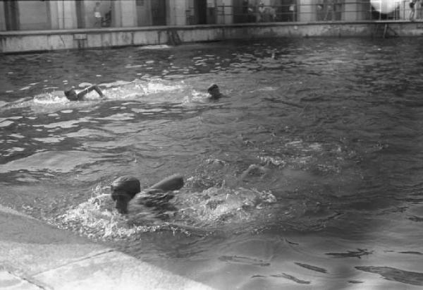 Località non identificata. Giovani nuotano in piscina