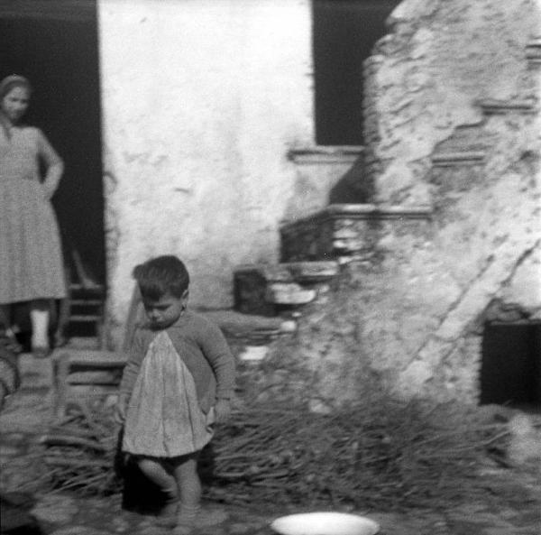 Melissa (Crotone) - Donna e bambino all'esterno di una casa