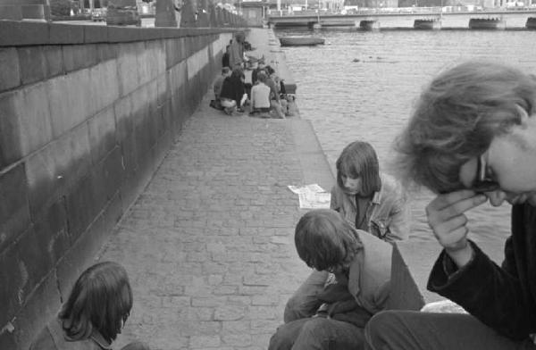 Svezia, Stoccolma - Gruppi di giovani seduti sul lungofiume che leggono e parlano fra loro