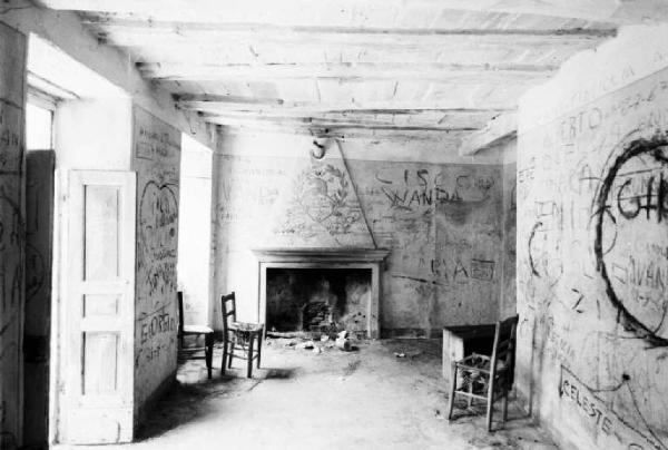 Interno di casa abbandonata - Sala del caminetto con muri coperti di graffiti