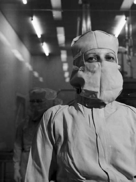 Glaxo - Ritratto di un ricercatore in camice bianco e mascherina in un laboratorio - sullo sfondo un altro medico