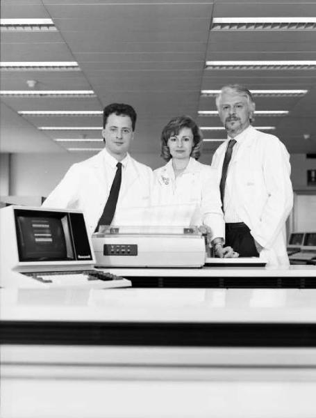 Glaxo - Ritratto di tre medici in camice bianco di fronte ad un calcolatore elettronico