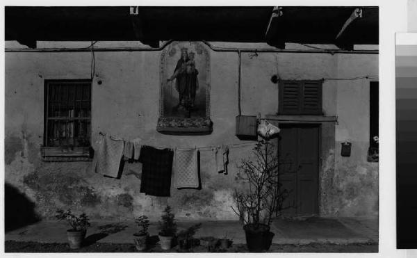 Brugherio - frazione di Baraggia - facciata di un'abitazione con panni stesi - edicola votiva