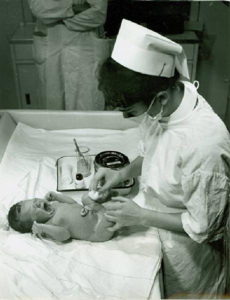 Ritratto infantile - Neonato con infermiera, negli attimi successivi al parto (la medicazione del cordone ombelicale)