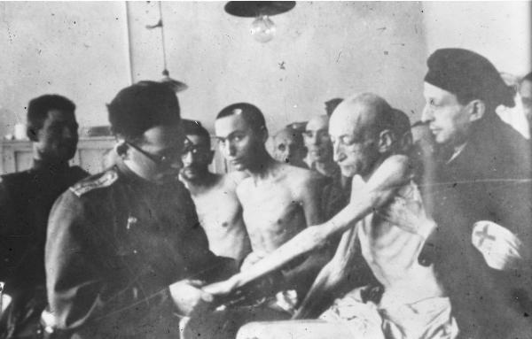 Seconda guerra mondiale - Polonia - Campo di concentramento di Auschwitz - Nazismo - Dopo la liberazione - Infermeria - Uomo prigioniero sopravvissuto visitato da un medico sovietico in divisa